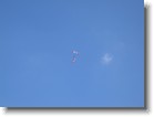A paratrooper gliding in with an American flag.