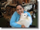 Ashley holding a stuffed American Eskimo dog.