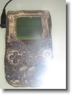 A flash-obstructed photo of the original Gameboy which was incenerated during the first Gulf War.